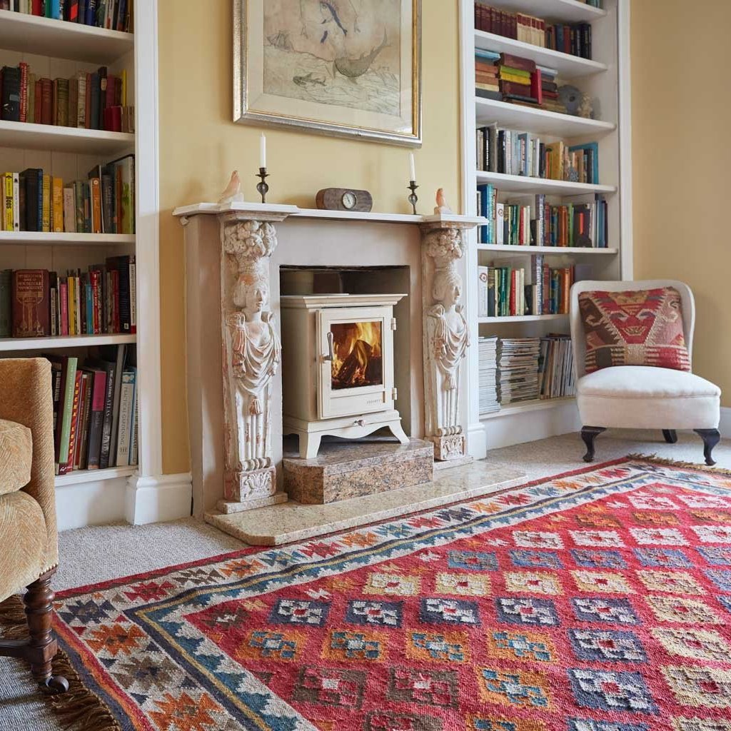 Nomad Patara Rug in living room with fireplace, chairs and book case